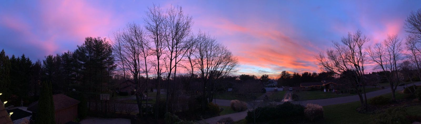 Panorama of pink sunset clouds over a Long Island neighborhood