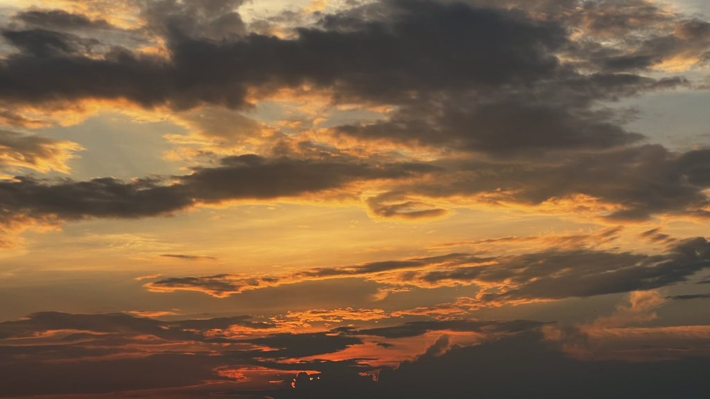 Dark clouds edged in gold at sunset